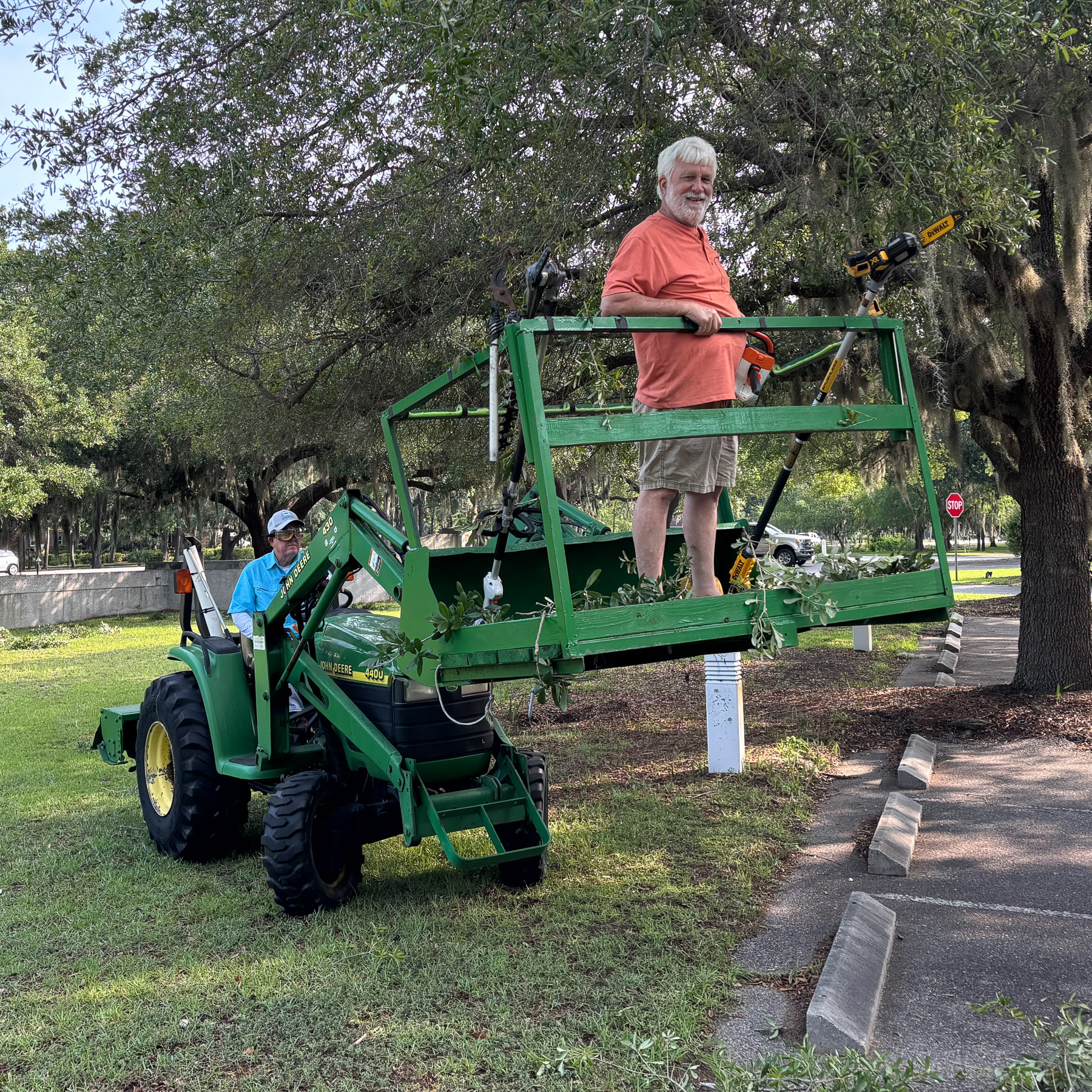 Men trimming trees during a Campus Workday.